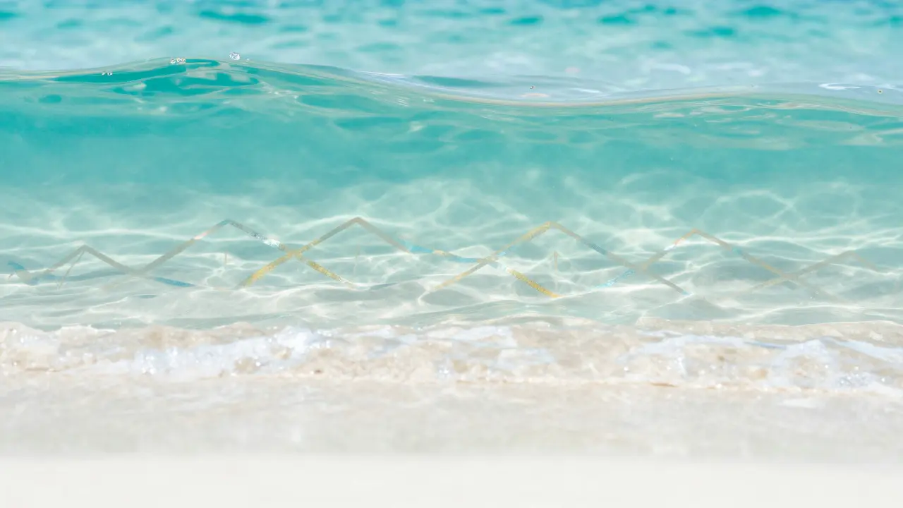 Křišťalově čistá mořská vlna s jemnými symboly molekulární struktury kolagenu.